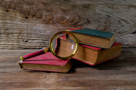 Vintage magnifying glass with old books. Concept for learn history.の写真素材