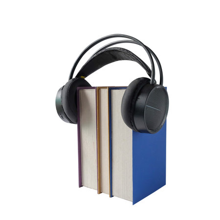 Headphones and a stack of books, played as audio through the books.の写真素材