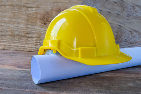 Drawings Architect rolls  and  safety helmet on the desk.の写真素材