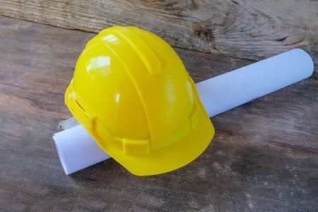 Drawings Architect rolls  and  safety helmet on the desk.の写真素材