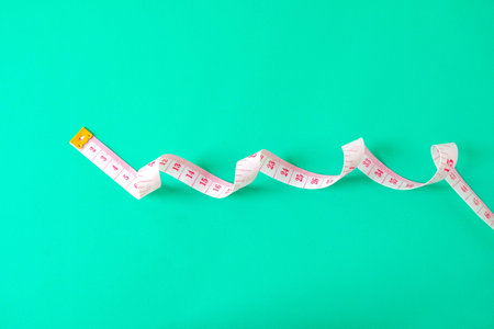 A  measuring tape displaying measurements in numbers on color background.の写真素材