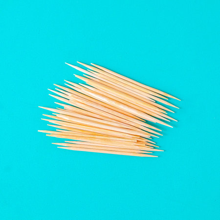 Group of toothpicks made of bamboo scattered across a background.