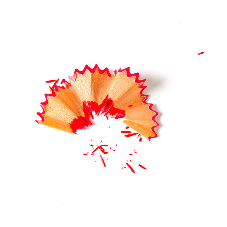 Red pencil tip shavings from sharpener on white background .