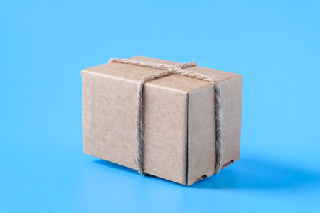 Box wrapped in craft paper and tied with vintage hemp ribbon .