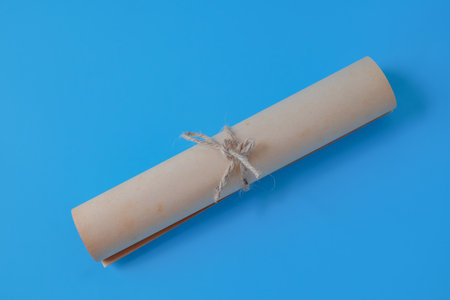 Ancient paper scroll and tied with a rope on a color background.の写真素材