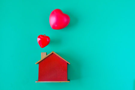 Wooden house model and red heart.の写真素材