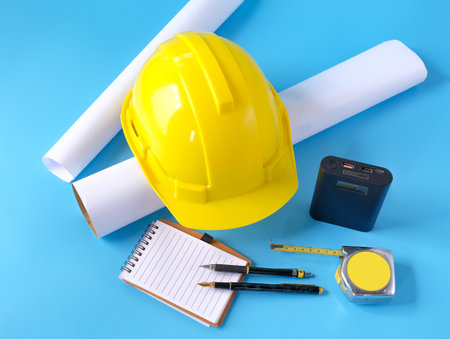 Helmet and tape measure on background,working on construction project.