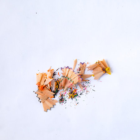 Color wooden pencil and pencil shavings on white.