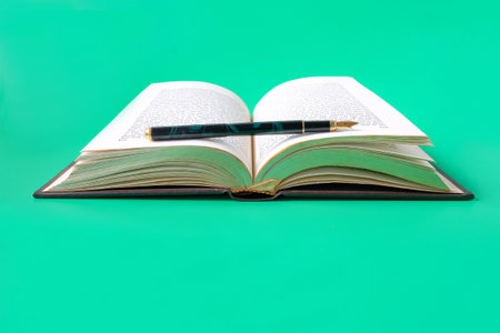 Pen on an old book background.の写真素材