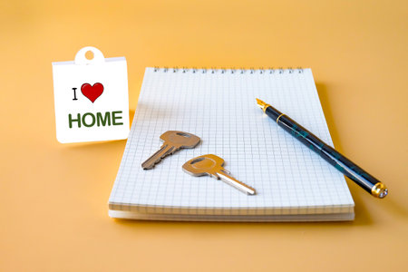 Fountain pen on book note and key with tag love home.の写真素材