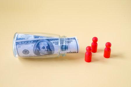 Wooden figure standing to Bank notes in a glass jar. Money Saving, Financial Planning and Economy Concept.の写真素材