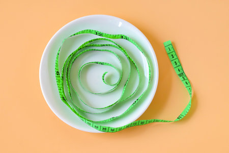 Green measuring tape on white surface.