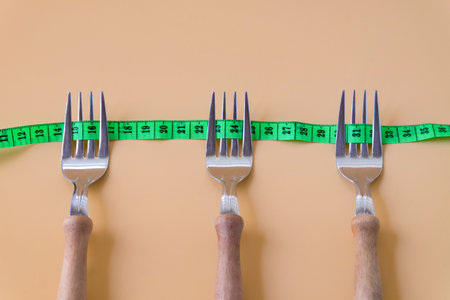 Green measuring tape on three forks.Healthcare concept.の写真素材