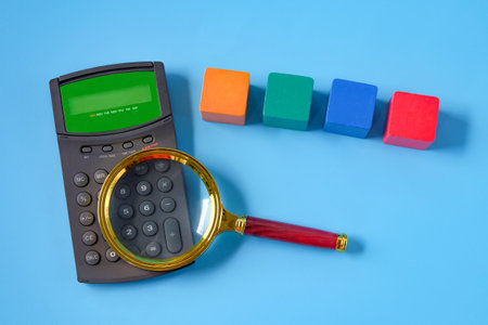 Magnifier glass with calculator and color wood cube.の写真素材