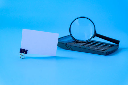 White card with magnify glass on calculator.の写真素材
