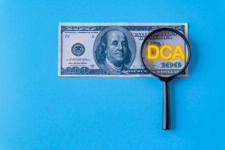 DCA text on magnifying over dollar bank note.の写真素材