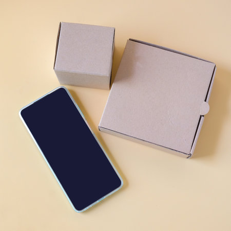 A smartphone placed on a brown paper box, technology and packaging concept.の写真素材