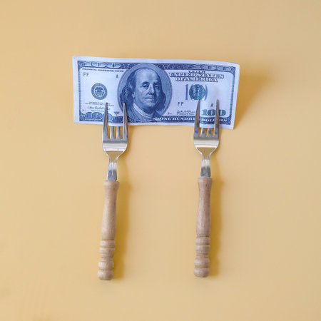 A dollar note on end of fork. Business concept.の写真素材