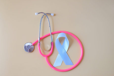 Blue ribbon and stethoscope on color background.の写真素材