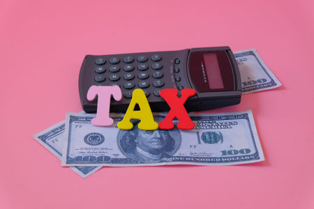 Calculator with bank note in tax concept.