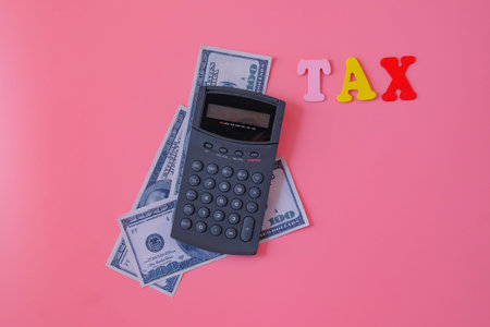 Calculator with bank note in tax concept.