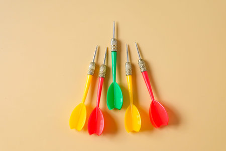 Colorful plastic darts on color background.