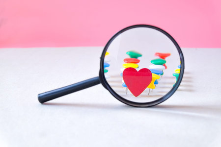 Magnifying glass on decorative red heart and push pin. valentines day concept.の写真素材