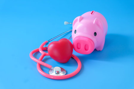 piggy bank with stethoscope and red heart on color background.の写真素材
