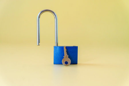 Unlocked blue padlock with key on color background.の写真素材