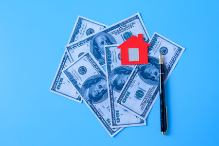 Mini Red house on bank note on color background.