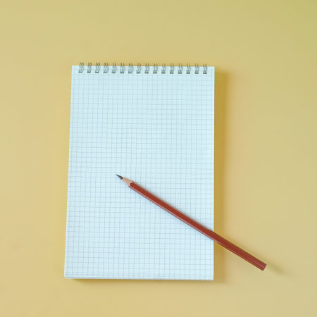 A pencil with a book on a color background.