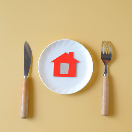 Minimal red house on white dish fork,spoon and knife.