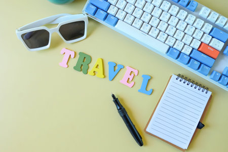 travel colorful word on office desk with keyboard,sunglasses and notebook