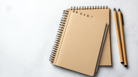 Recycled paper notebooks and pens made from bamboo, placed on a clean surface. Copy space.の素材