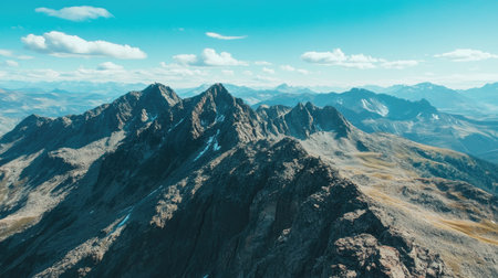 Aerial perspective of a rocky mountain range with open sky above, ideal for text placementの素材