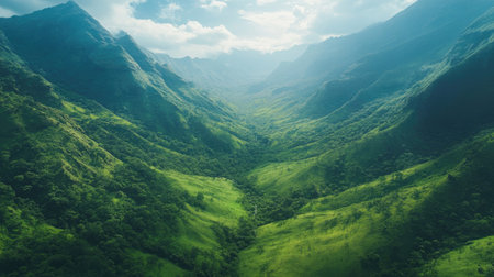 Overhead shot of a lush green valley nestled between mountain ridges with plenty of copy space in the skyの素材