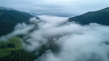 Aerial shot of a mountain landscape with misty clouds, open sky area for textの素材