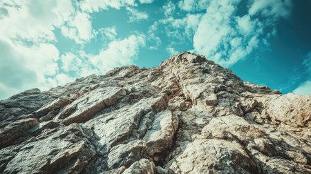 High-angle shot of a rocky mountain peak with a large expanse of sky, ideal for inserting text or logosの素材