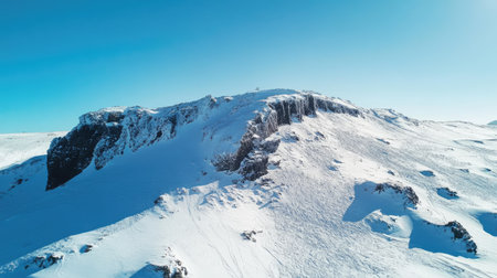 High-angle view of a snowy mountain with a clear sky, perfect for placing a messageの素材