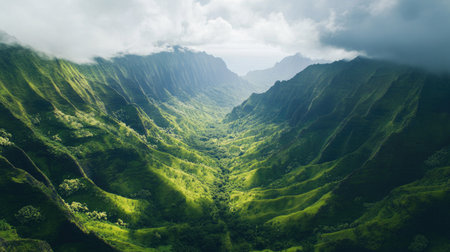 Overhead shot of a lush green valley nestled between mountain ridges with plenty of copy space in the skyの素材