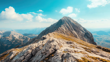 Top view of a rugged mountain peak with a large expanse of blue sky, perfect for a messageの素材
