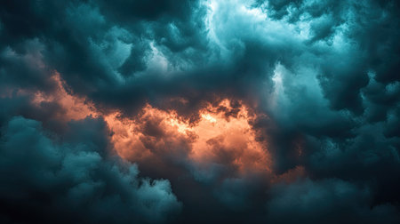 A dark, stormy sky with patches of clouds bathed in warm light, illustrating contrast between turmoil and clarityの素材