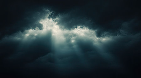 Dark sky with clouds illuminated by a mysterious light, symbolizing hidden potential and emerging ideasの素材