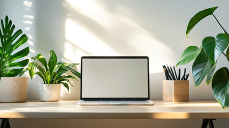 A minimalist home office with a clean desk, laptop, and plants, offering plenty of space for copy or textの素材