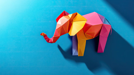 Top view of a colorful paper elephant, showcasing detailed folds and shadow play on a blank surface. Copy space available5の素材