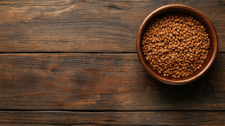 Top view of a bowl filled with dry pet food, set on a wooden surface, with ample copy space for textの素材