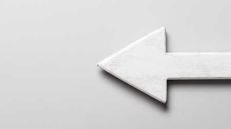A minimalistic white arrow pointing left against a subtle light gray background, ideal for use in design projects, signs, or visual communications needing directional cues.の素材