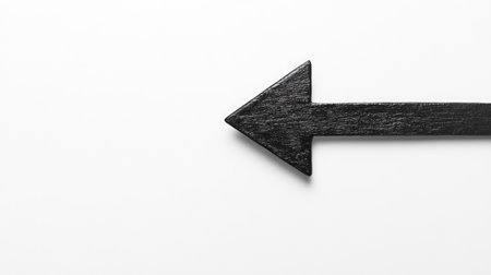 A minimalist black wooden arrow pointing left on a stark white background, perfect for graphic designs, marketing materials, and directional signs. Simple and clear.の素材