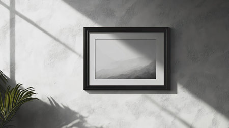 A minimalistic black and white landscape artwork framed elegantly on a textured wall, enhanced by subtle shadows and light, creating a serene atmosphere.の素材