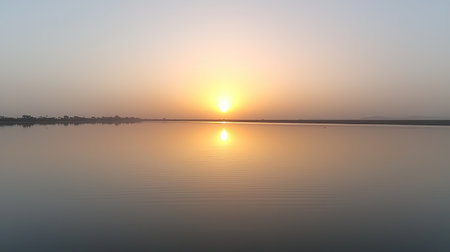 A calm stretch of the Niger River at sunrise, with reflections of the sky on the water. Copy space.の素材